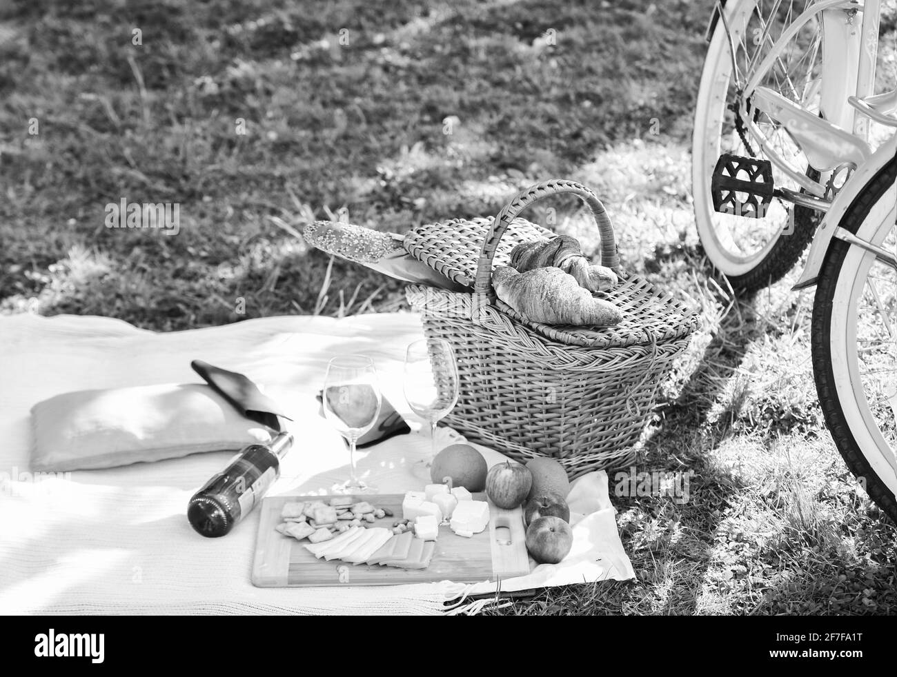picnic basket with food on blanket. spring eating outdoor. family day. all goods for picnic. love date. vintage bicycle on green grass. green summer Stock Photo