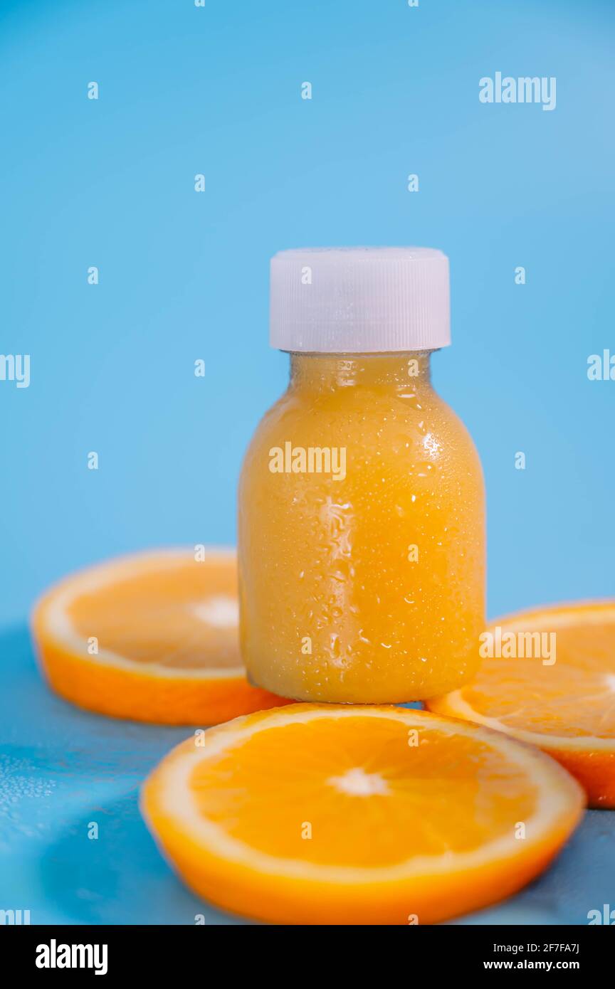 Composition with bottles of fresh orange juice and slices of fresh