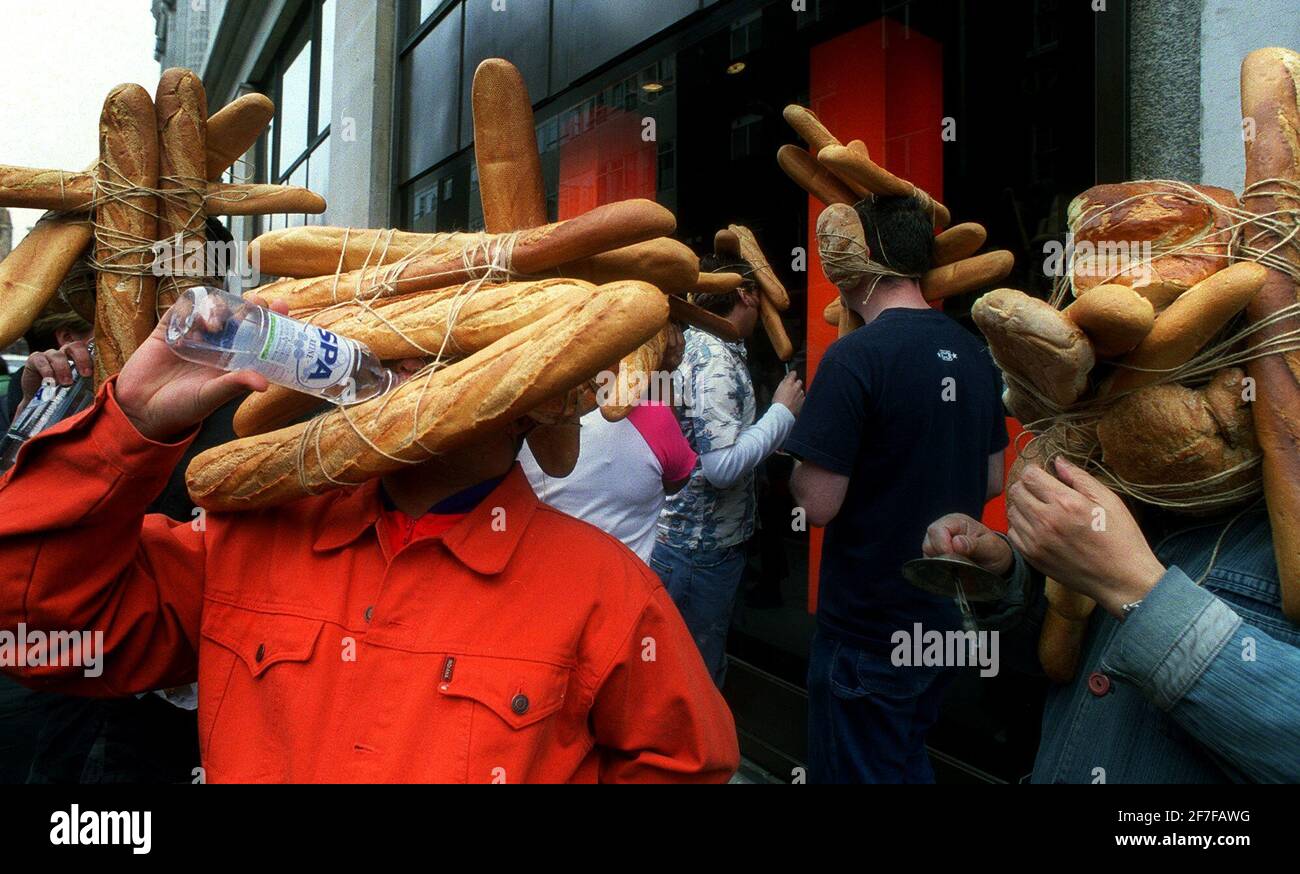 Japanease artist Tatsumi Orimoto May 2001, leads a parade od people with loaves of bread along Oxford Street, outside Selfridges to coincide with Tokyo life. Tatsumi Orimoto is on the right leading. Stock Photo