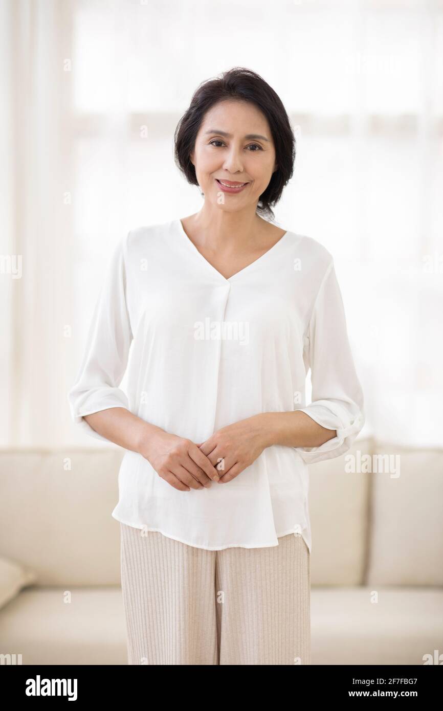Mature woman relaxing in living room Stock Photo - Alamy