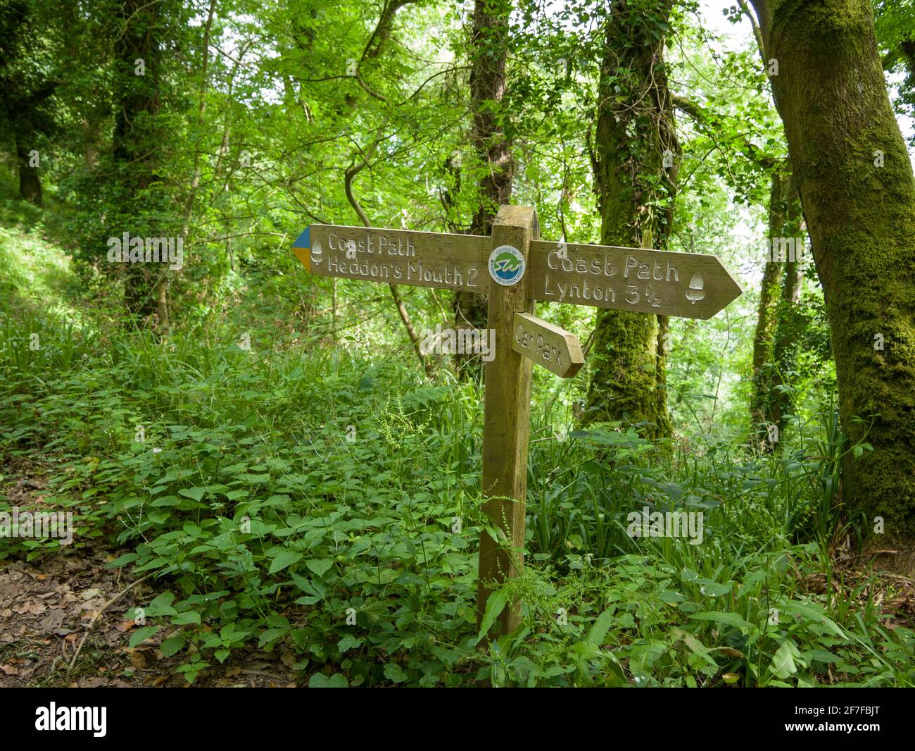 A footpath signpost to Heddon’s Mouth and Lynton on the South West Coast Path at Woody Bay in Exmoor National Park, North Devon, England. Stock Photo