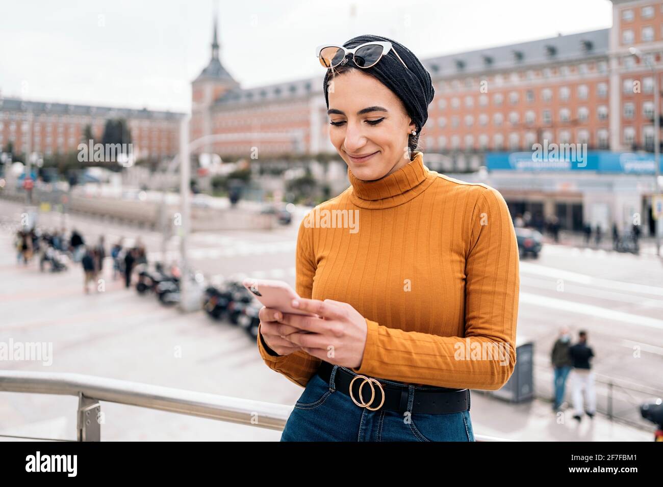 Pretty young muslim woman wearing head scarf using her mobile phone in ...