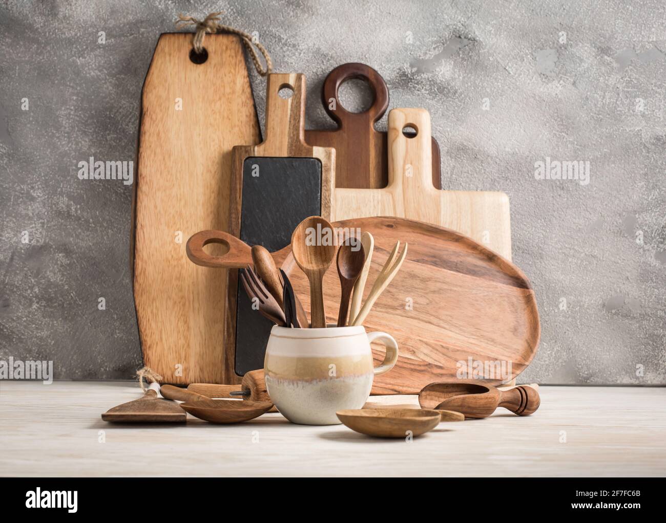Assortment of wooden cutting boards and kitchen utensils on wooden ...