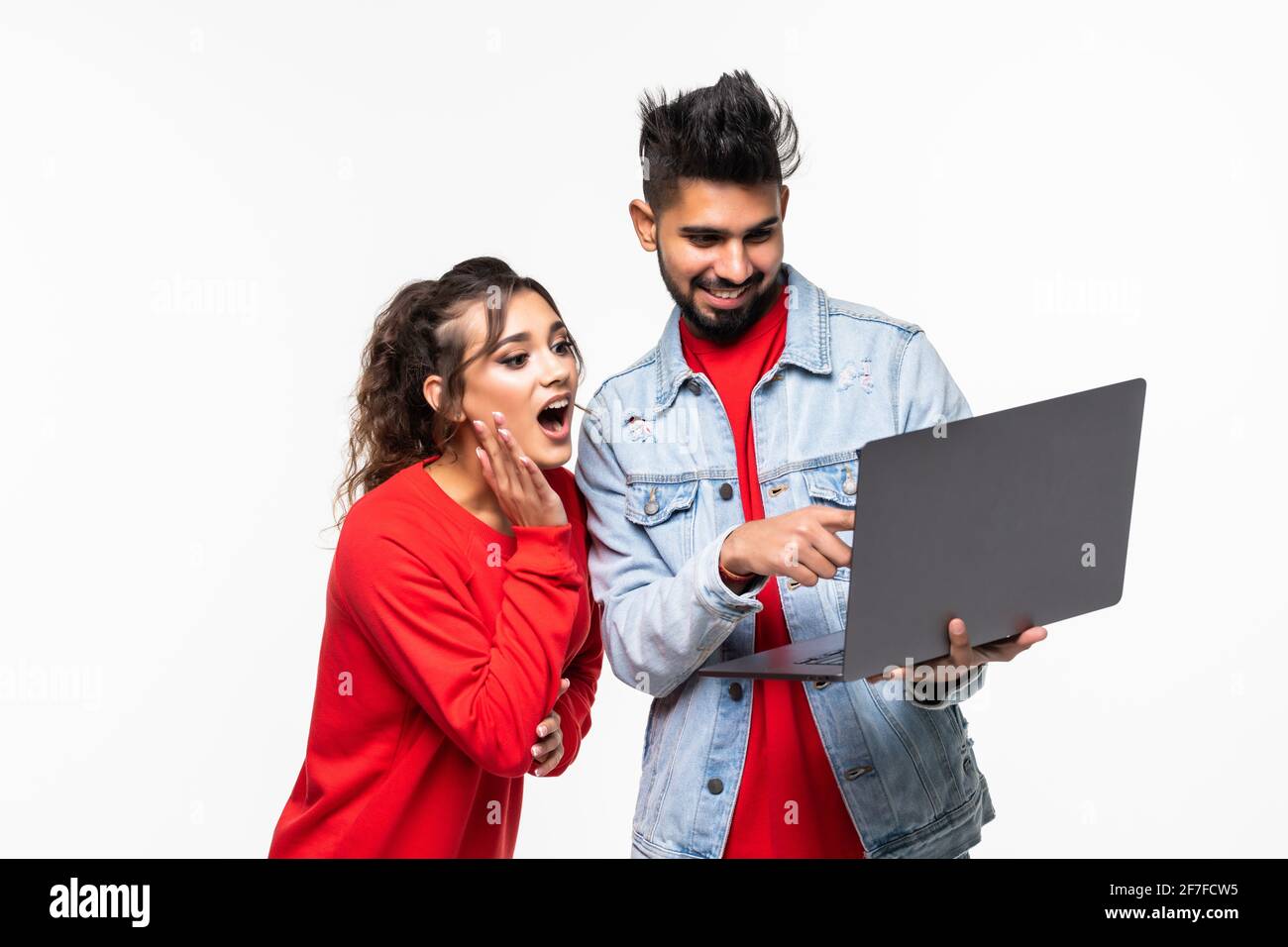 Attractive young couple holding their laptop on white background Stock ...