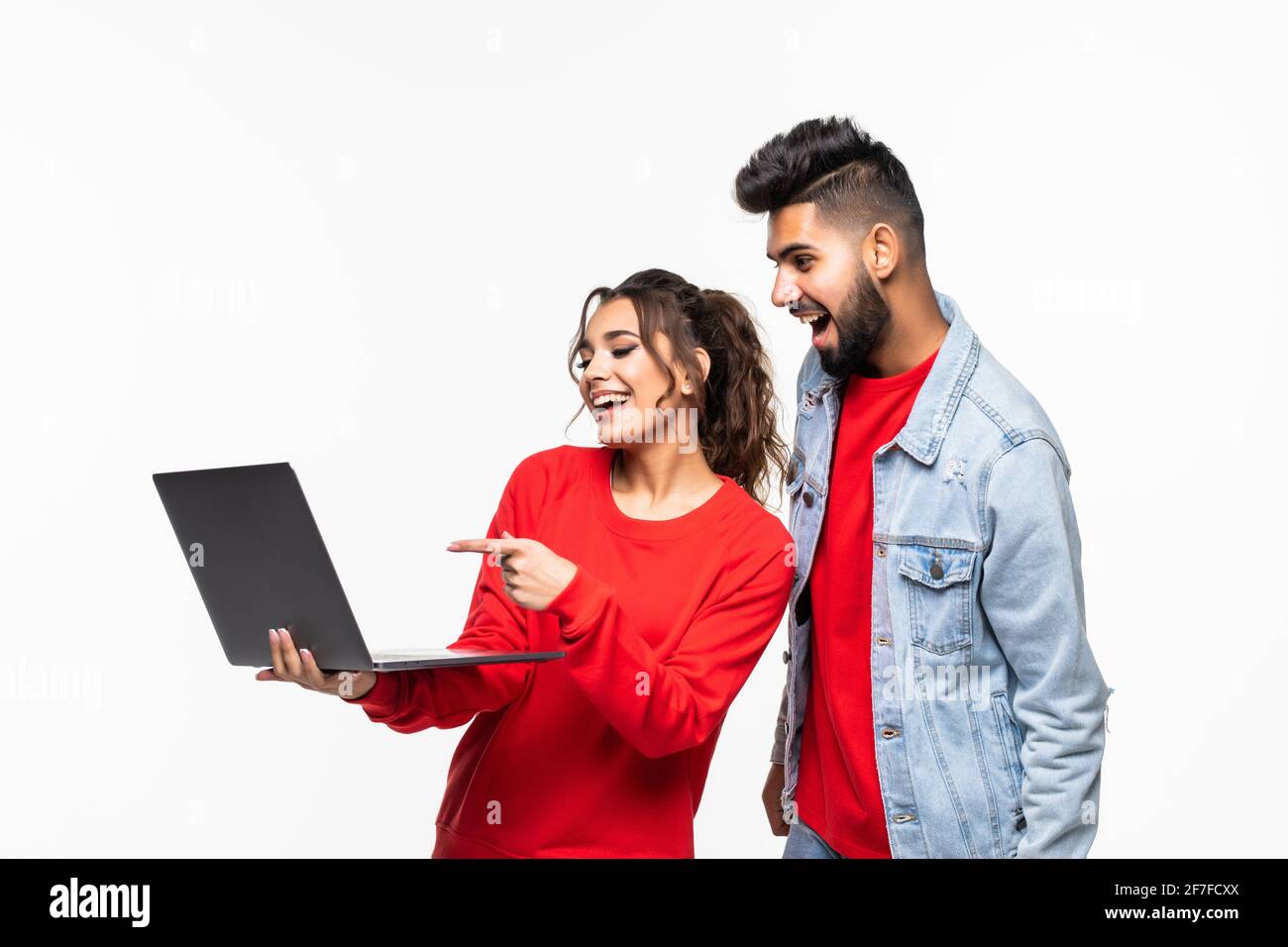 Attractive young couple holding their laptop on white background Stock ...