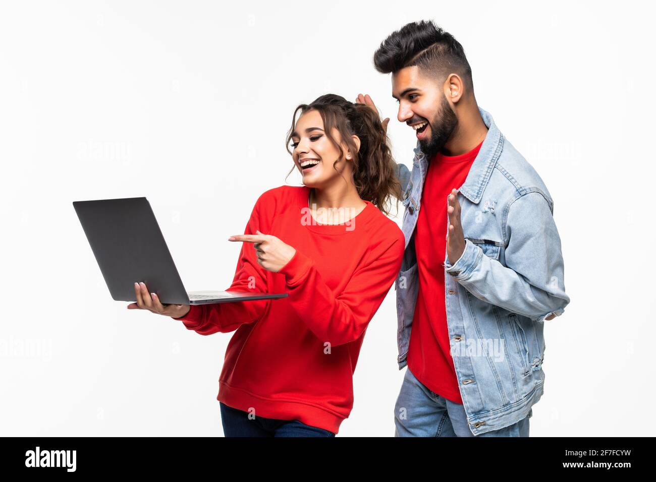 Attractive young couple holding their laptop on white background Stock ...