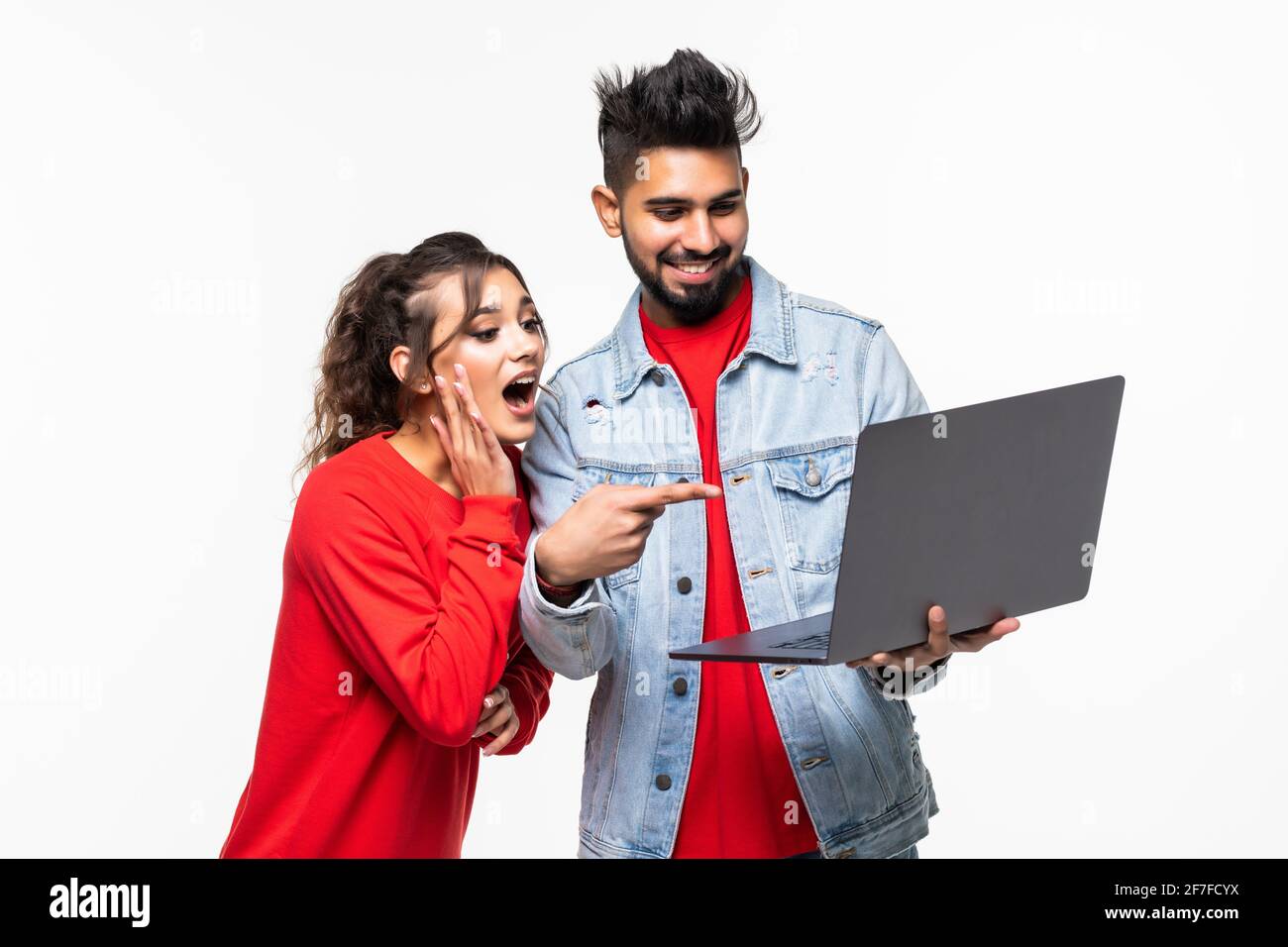 Attractive young couple holding their laptop on white background Stock ...