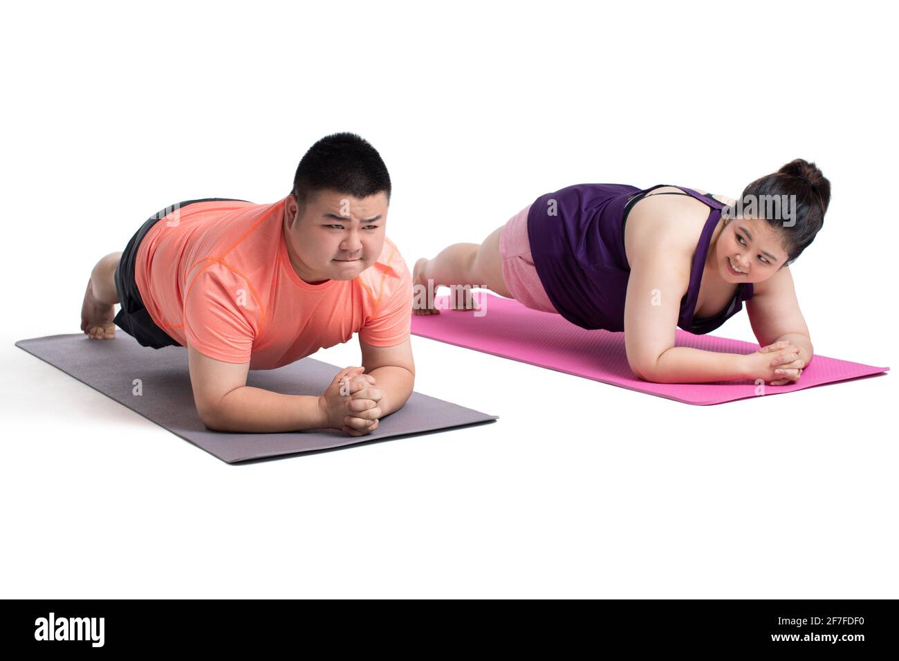 Overweight young couple doing plank position Stock Photo