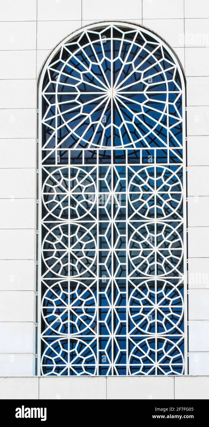 Large gray old window with ornamental metal lattice of building wall ...