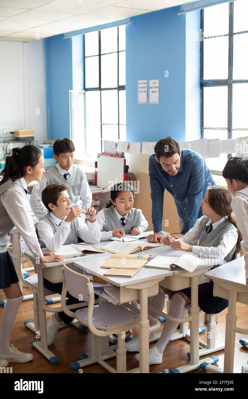 Teacher talking with students in classroom Stock Photo