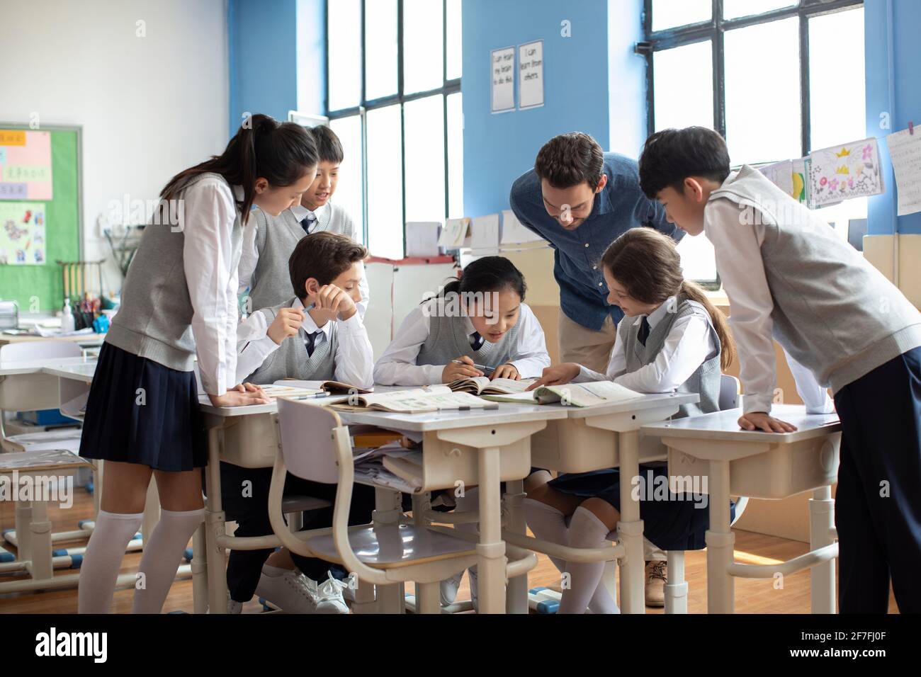 Teacher talking with students in classroom Stock Photo - Alamy