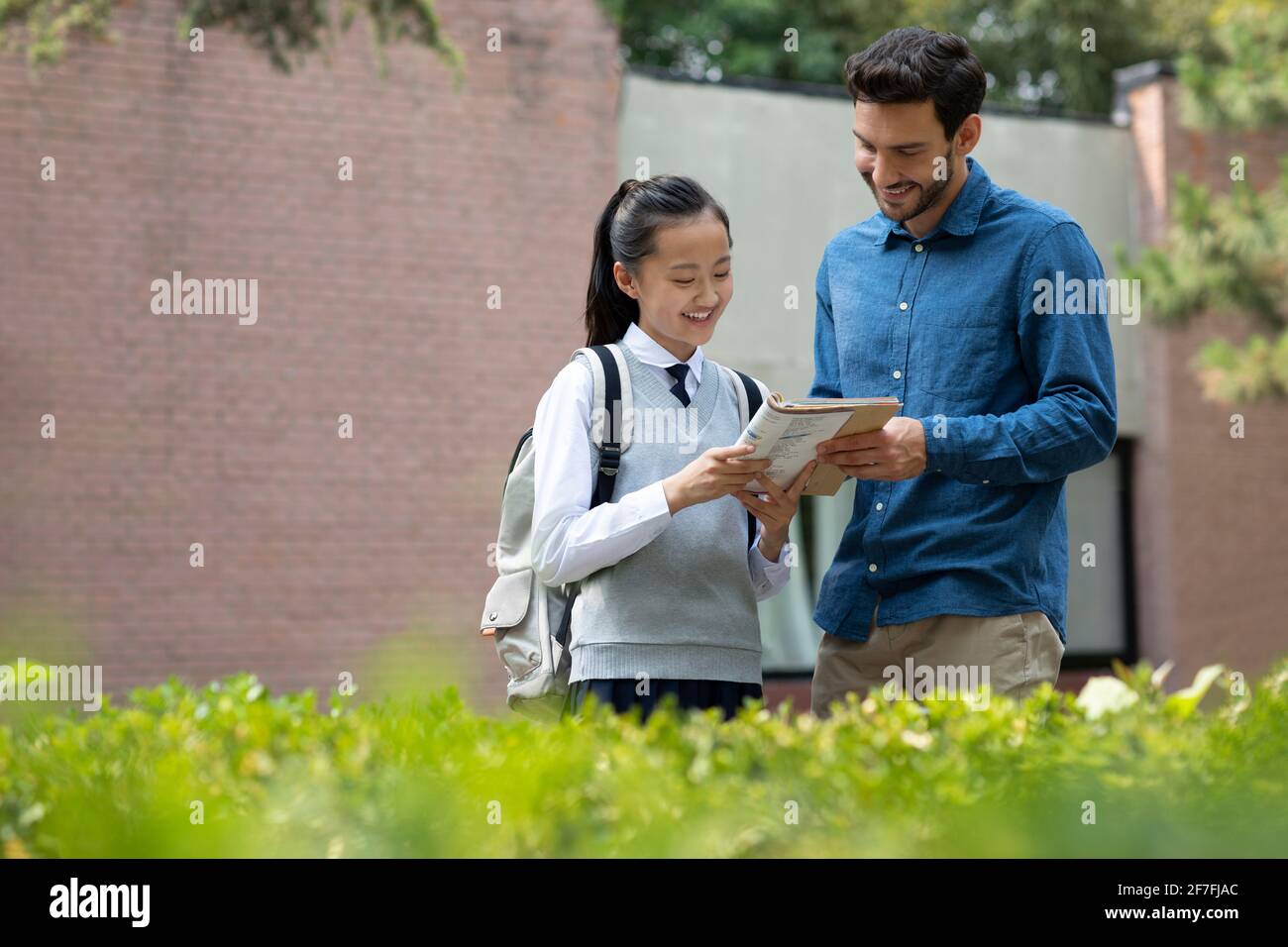 Schoolgirl asking teacher a question Stock Photo - Alamy