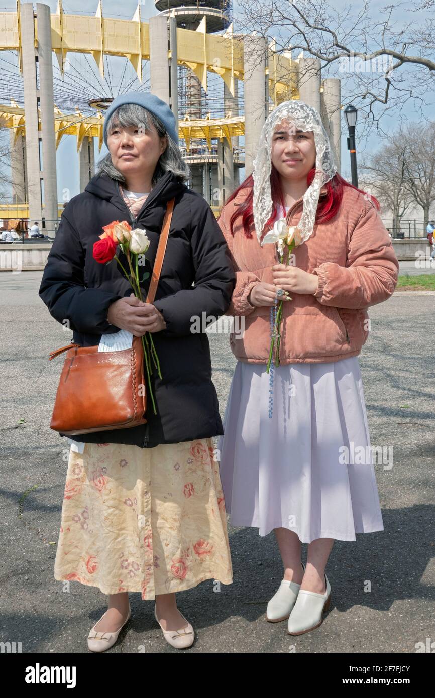 A mother & daughter pray at an outdoors service at the site of the '64