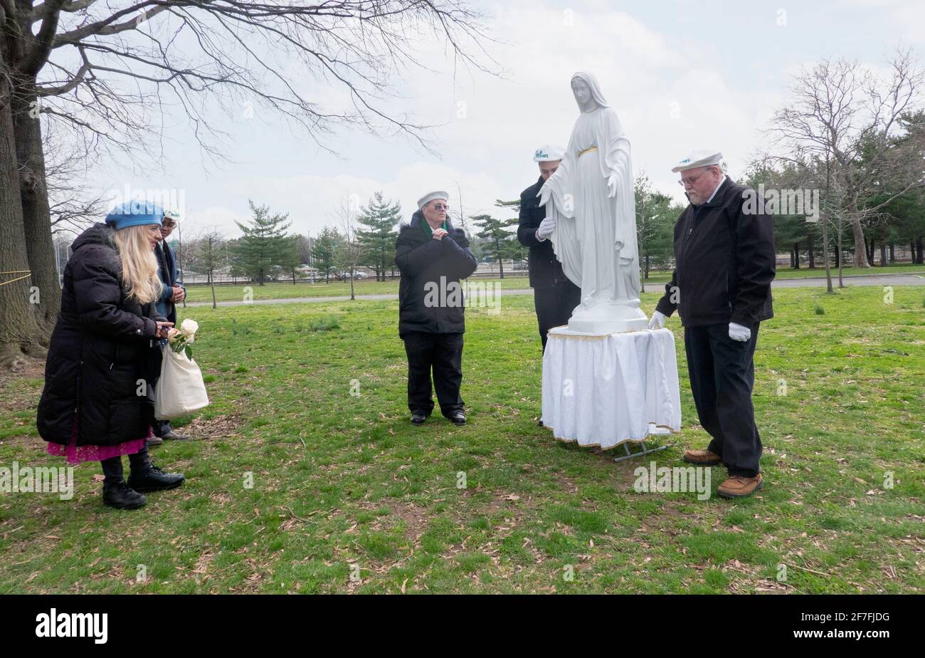 After a prayer service in a park, devout Roman Catholics pray to a statue of the Virgin Mary. At the site of Veronica Lueken's apparitions in NYC. Stock Photo
