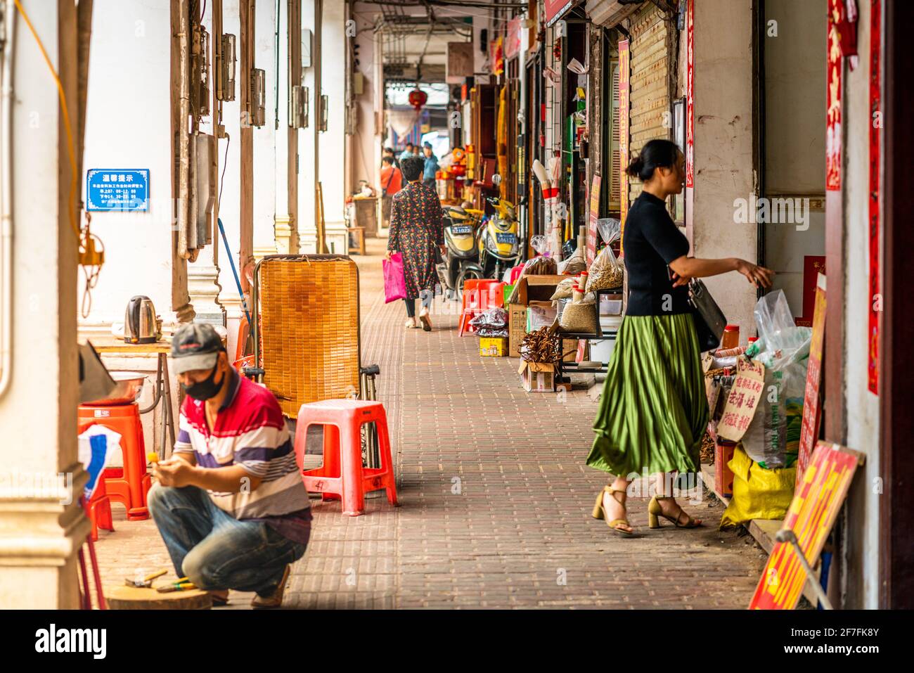Haikou China , 21 March 2021 : Scene from everyday life under pedestrian arcade street of Qilou old town with people and shops in Haikou Hainan China Stock Photo