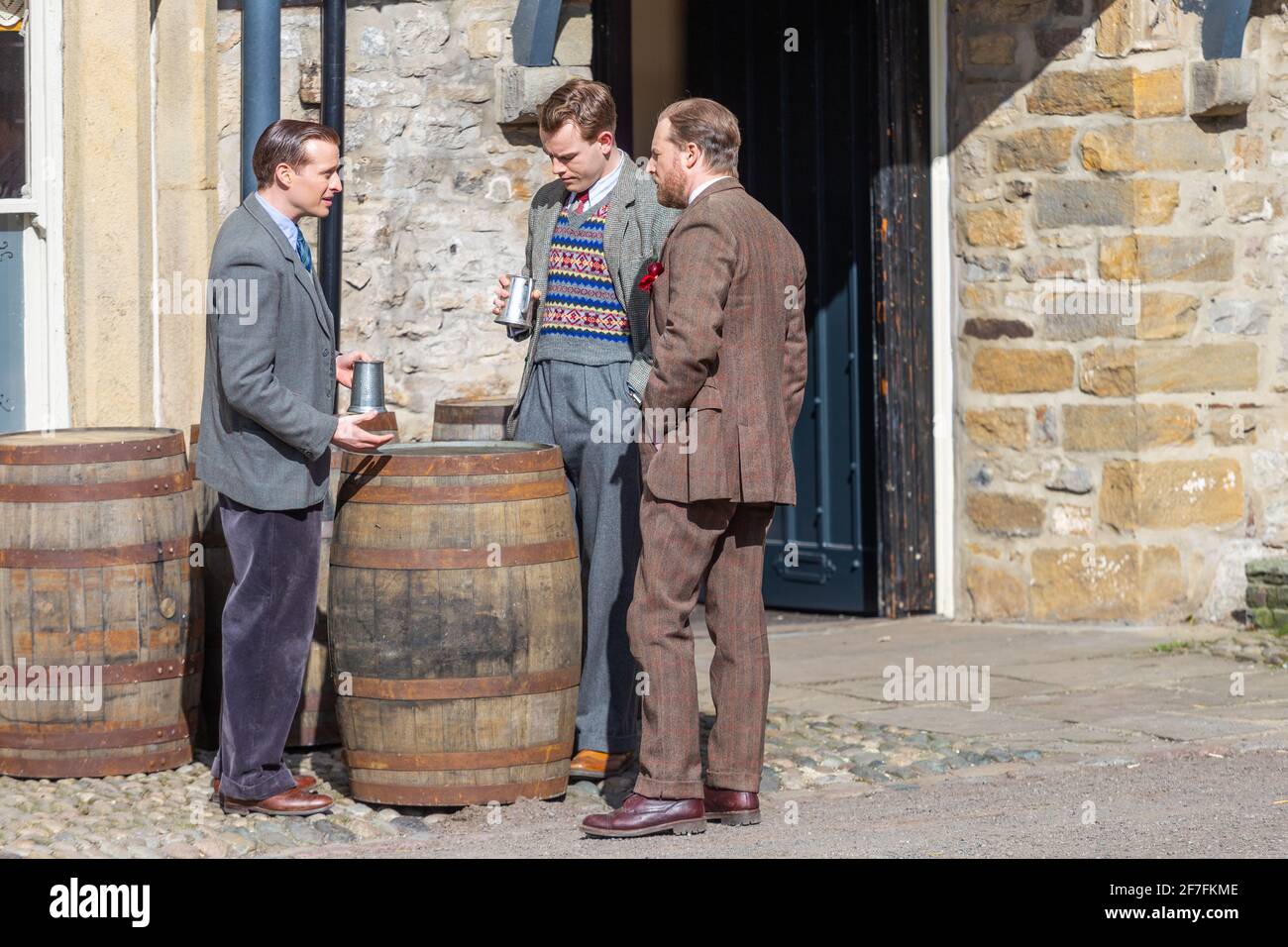 Grassington, UK. 7th April 2021. Nicholas Ralph (James Herriot), Samuel West (Siegfried Farnon) and Callum Woodhouse (Tristan Farnon) rehearse a scene during filming for the second series of the Channel 5 re-make of All Creatures Great and Small takes place in village of Grassington in the Yorkshire Dales Nation Park. (Credit: Tom Holmes Photography / Alamy Live News) Stock Photo