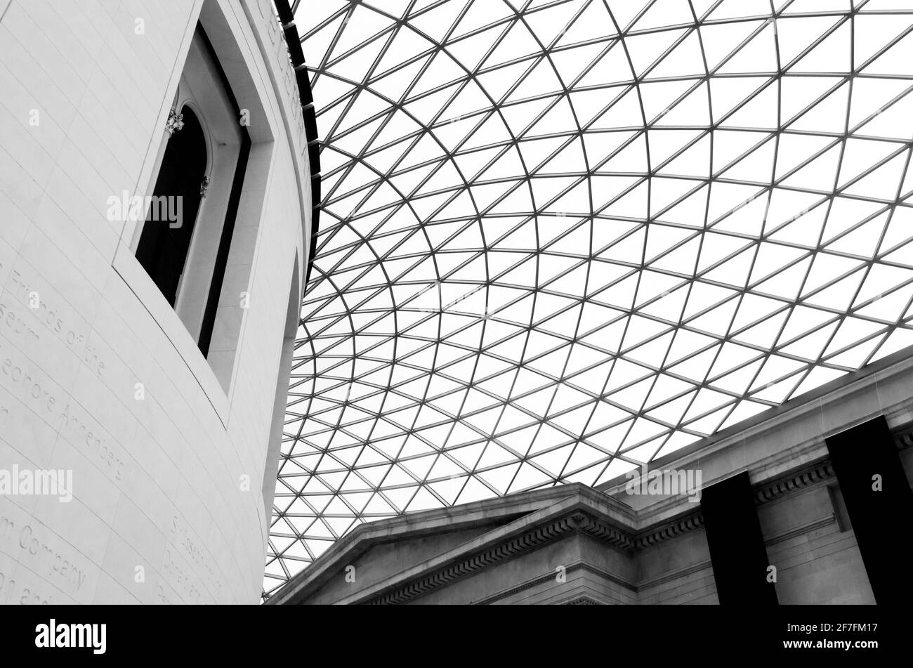 A window of the Reading Room, and tessellated, gridshell glass roof of the Queen Elizabeth II Great Court of the British Museum, London, UK. B&W Stock Photo