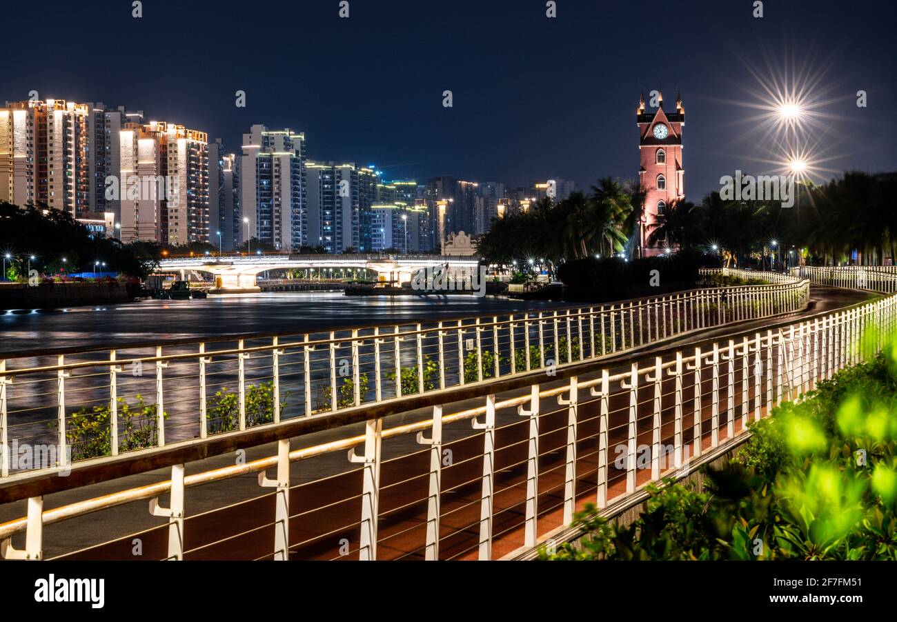 Beautiful Haikou cityscape at night with promenade along Haidian river and the Bell tower illuminated in Haikou Hainan China Stock Photo