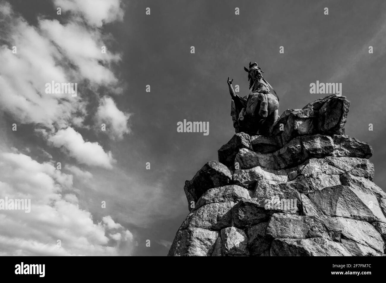 The Copper Horse statue ( of George III) at oneend of the Long Walk, Windsor Great Park, Berkshire, UK, viewed frmo below with clouds behind. B&W Stock Photo