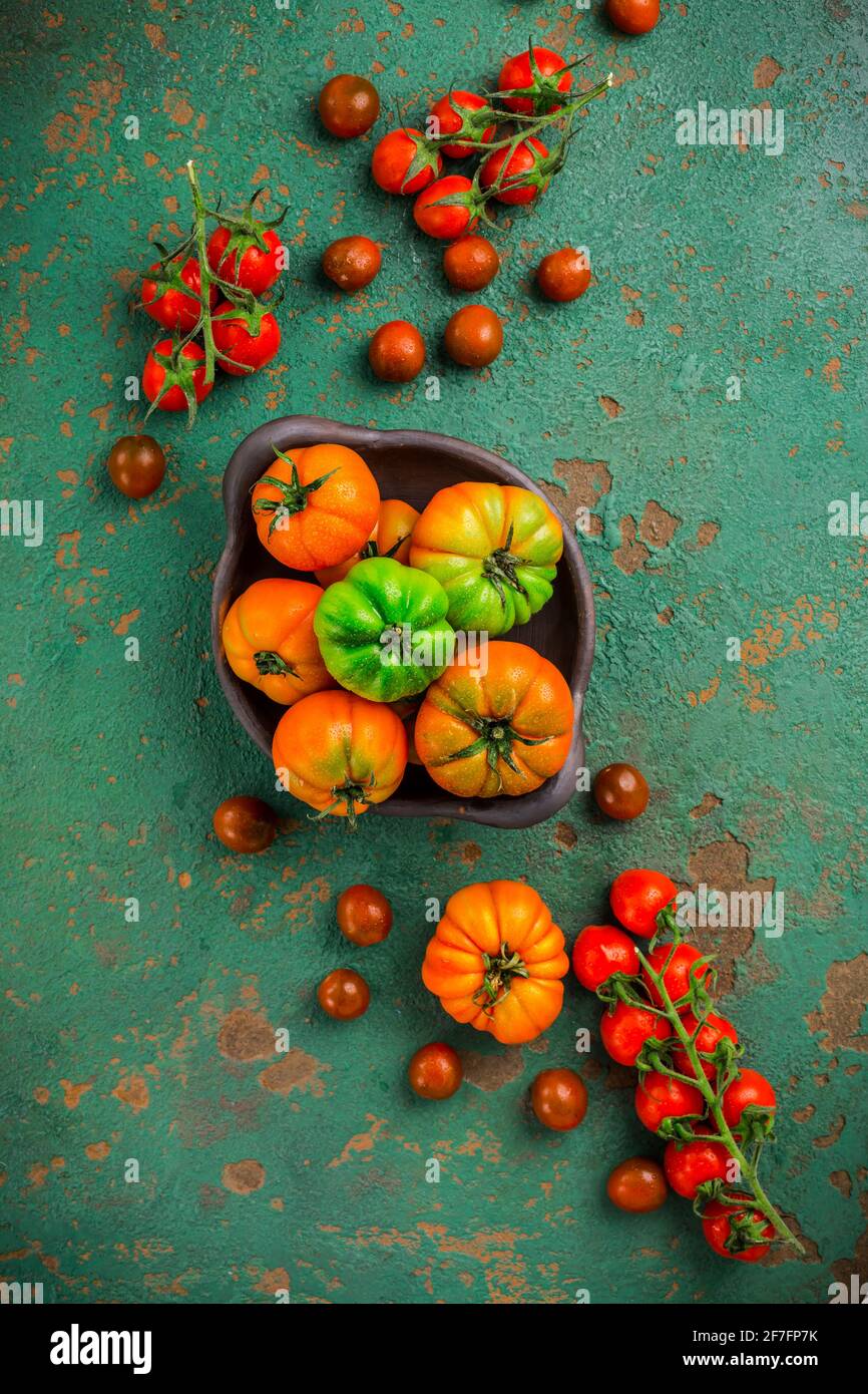Assortment of organic tomatoes on old kitchen table Stock Photo - Alamy