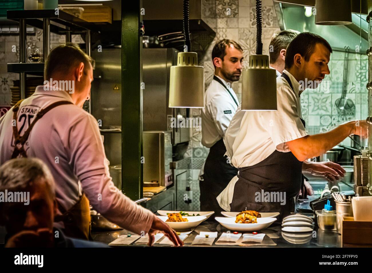 Perfectly organized in a confined space: László Papdi with colleagues in the open kitchen of Stand 25 in the Hold Street Market of Budapest, Hungary Stock Photo
