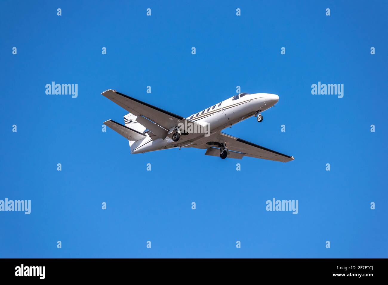 Business jet landing in blue sky Stock Photo