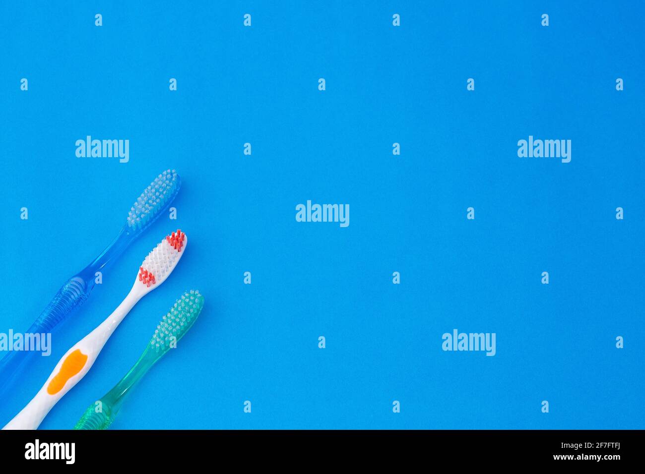 Three tooth brushes on blue background Stock Photo