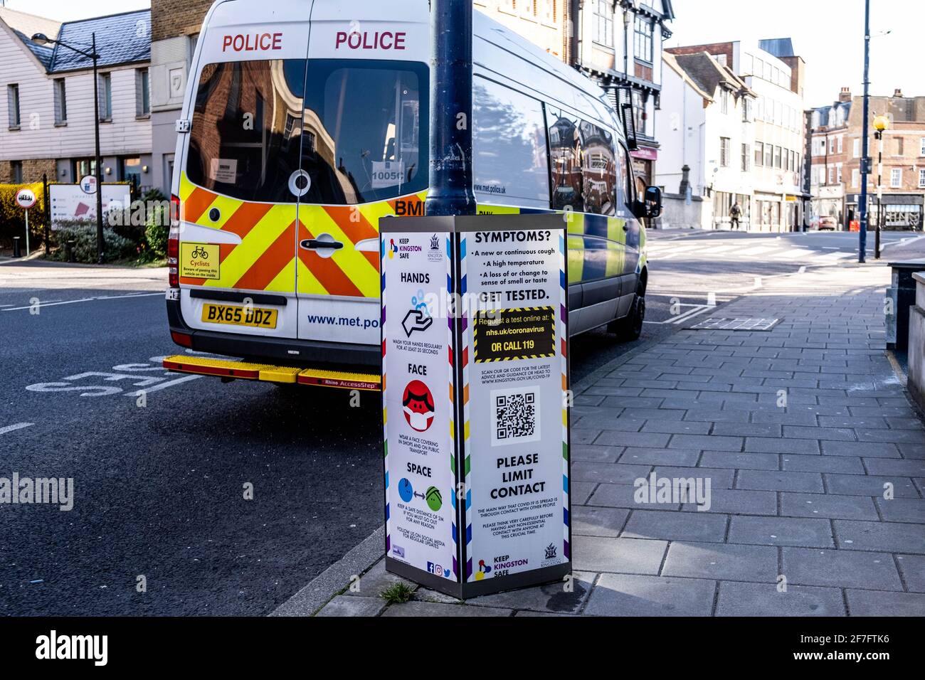 Kingston, London UK, April 7 2021, Police Riot Van Or Vehicle Parked Next To A Covid-19 Coronavirus Health Warning Sign Stock Photo