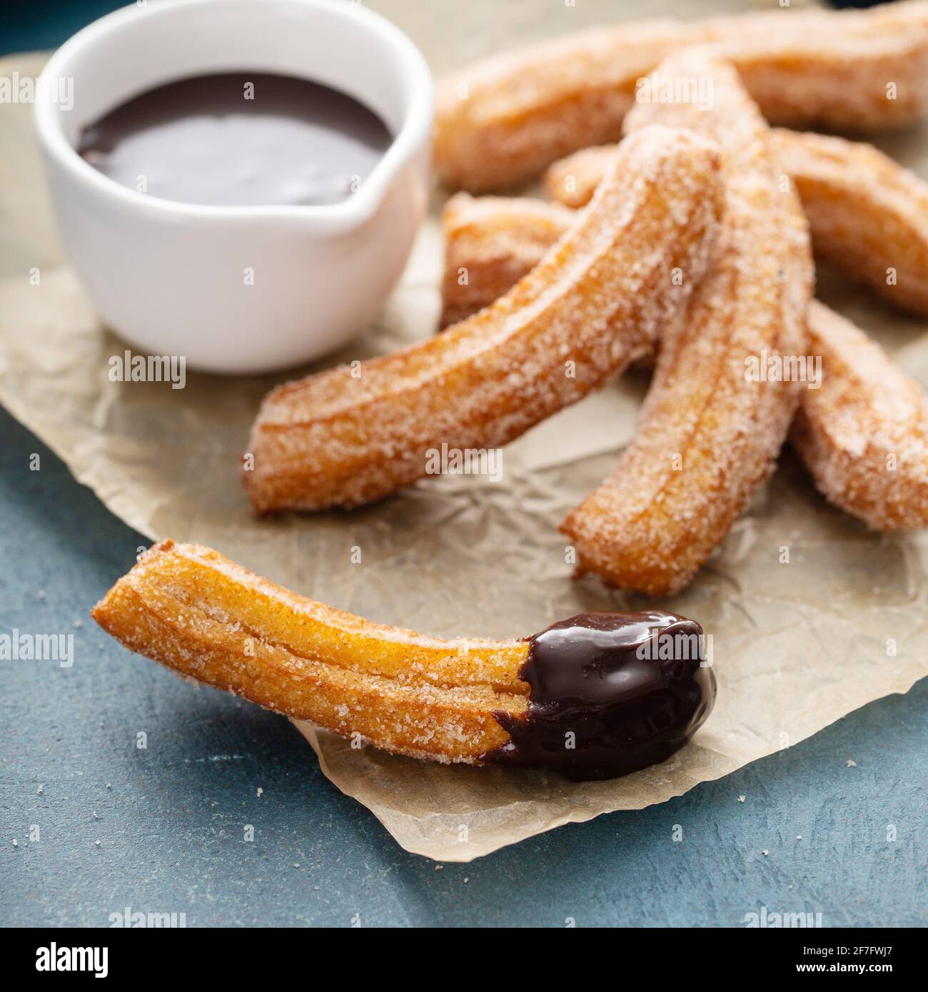 Homemade churros with cinnamon sugar on parchment Stock Photo