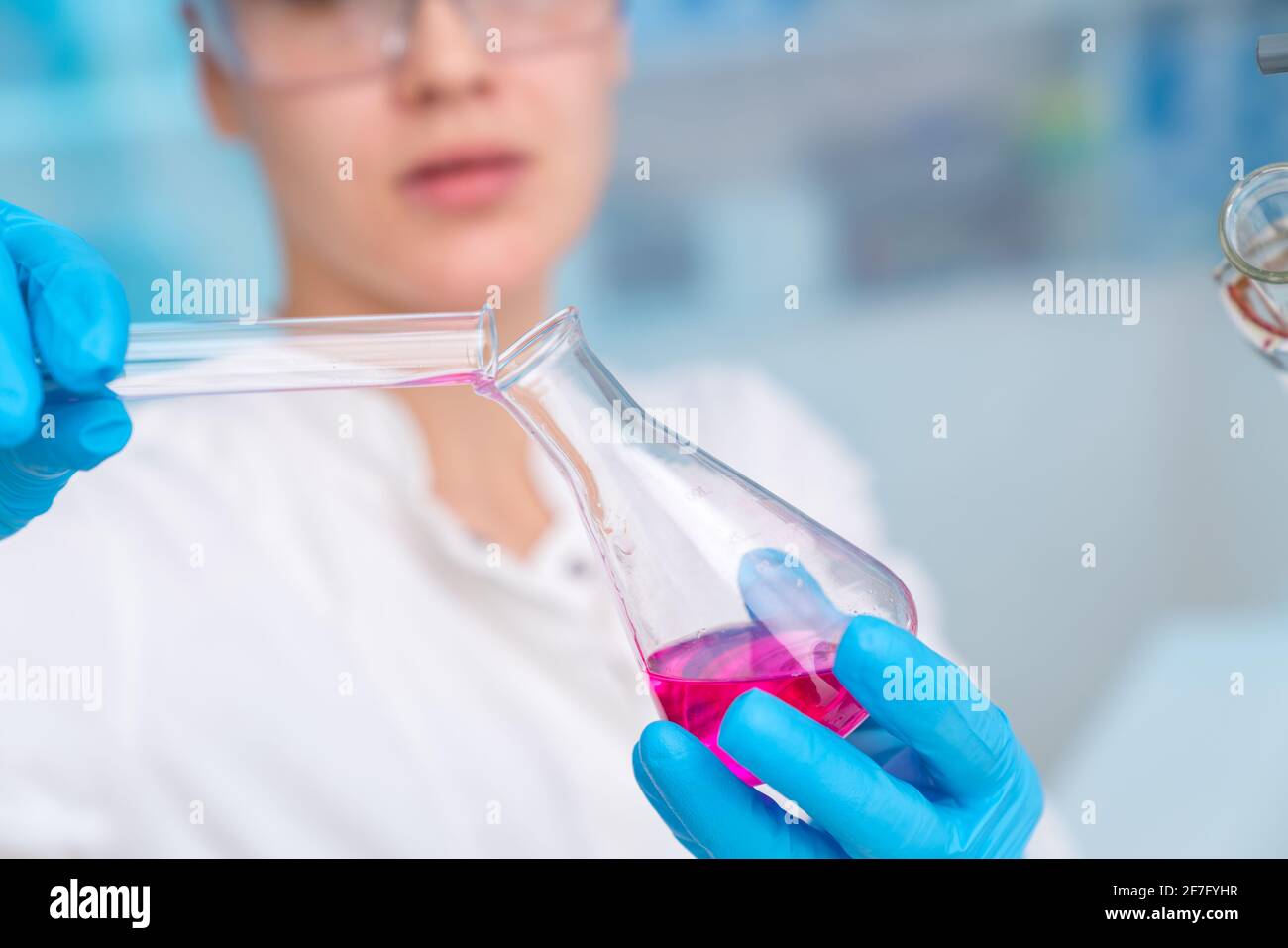 Young woman in chemical lab Young woman in chemical lab. cience professional pipetting solution into the glass cuvette. Stock Photo