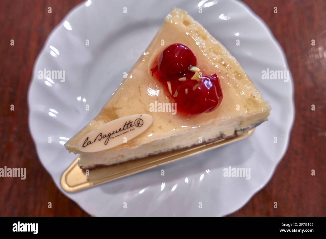 Lemon sponge cake. Lemon drizzle Victoria sponge layer cake with hard crust base and maraschino cherry topping fancy cake Stock Photo