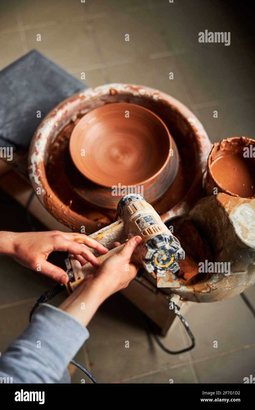 Potter using industrial dryer and making pottery in workshop Stock Photo