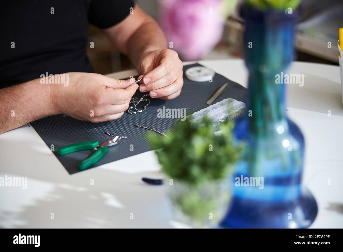 Professional jeweler seated at the table making a necklace clasp Stock Photo Alamy