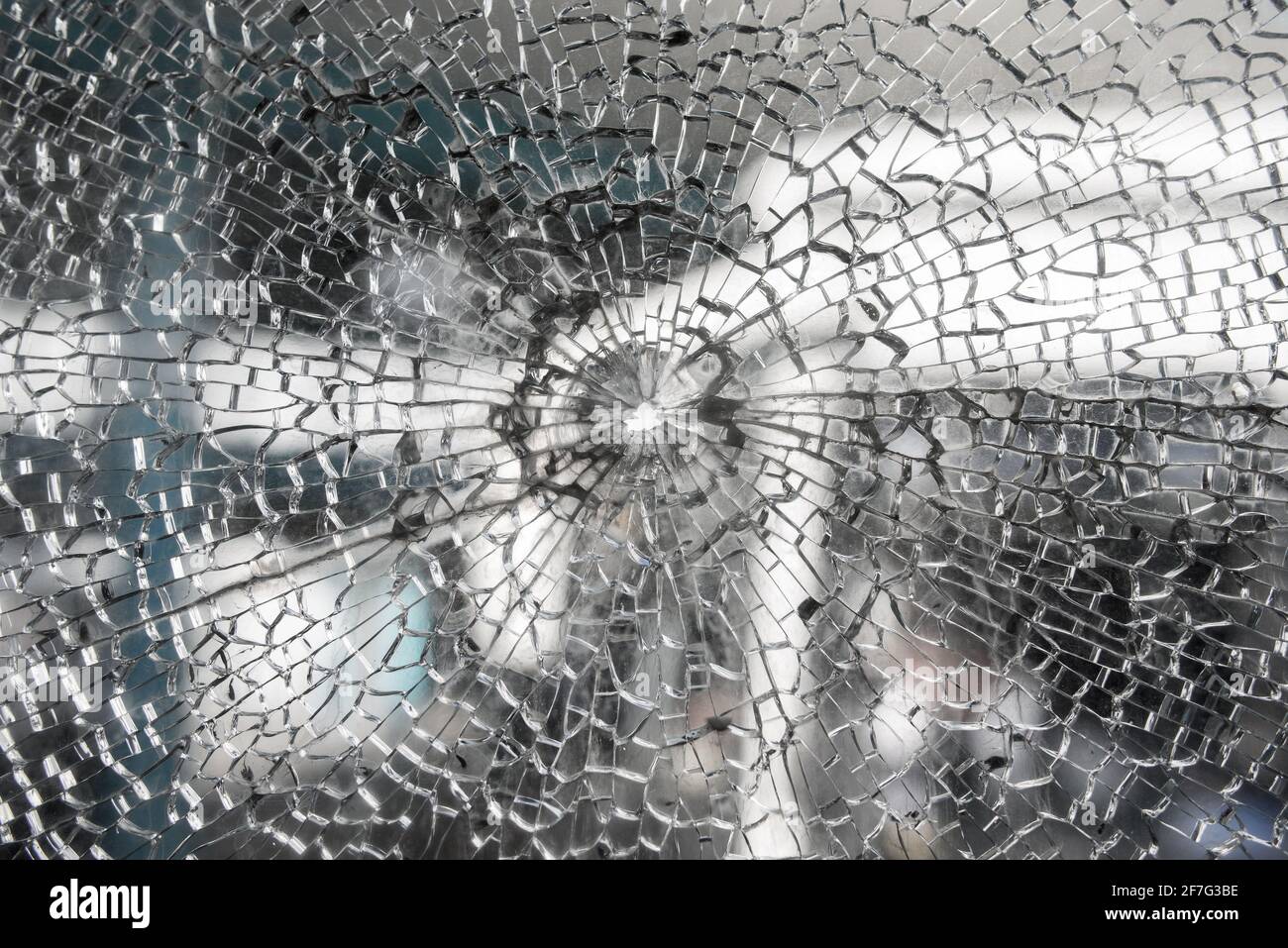 Cracked glass damaged window background with hole at center Stock Photo