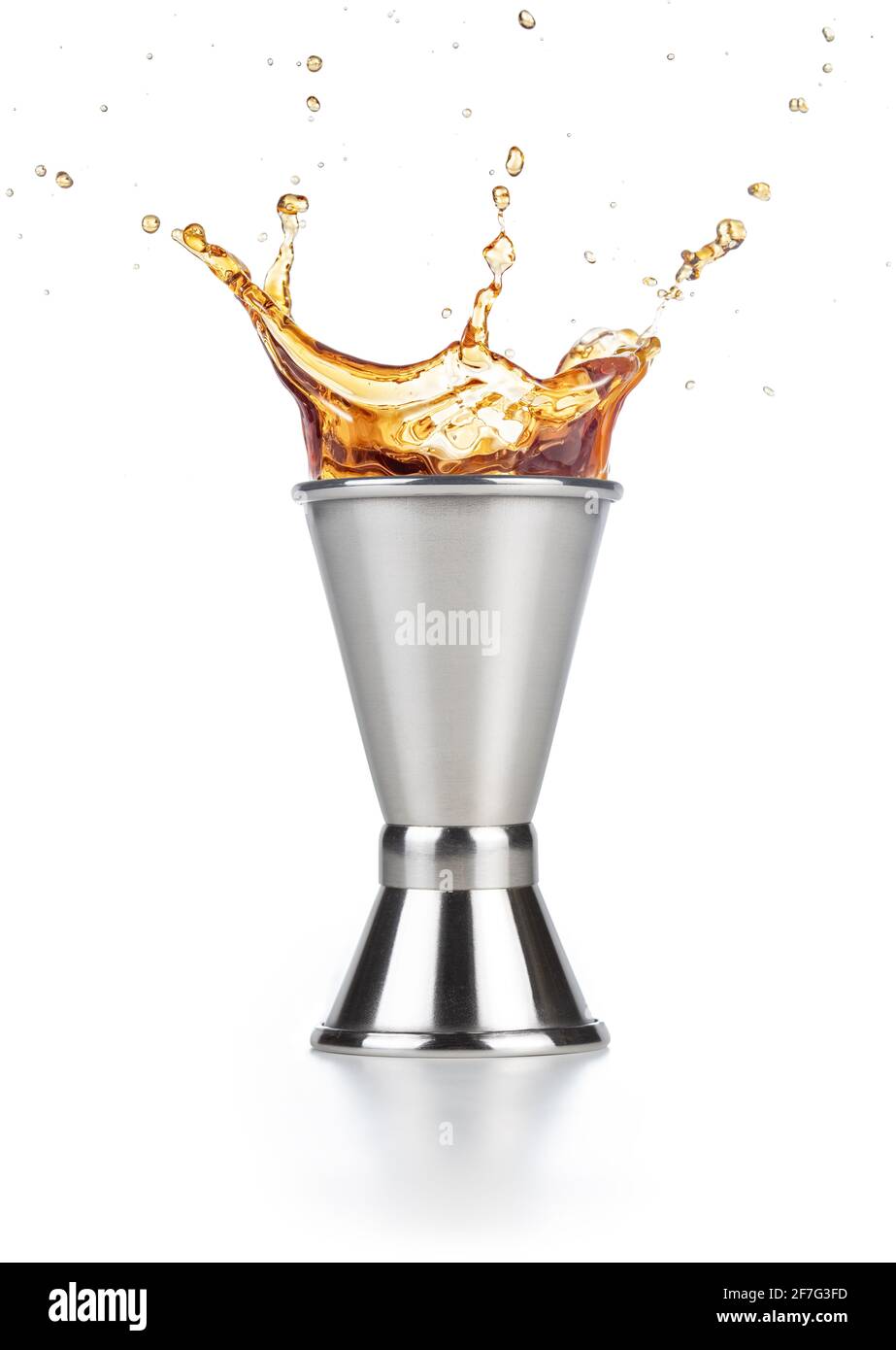 brown liquor splashing out of a jigger isolated on white background