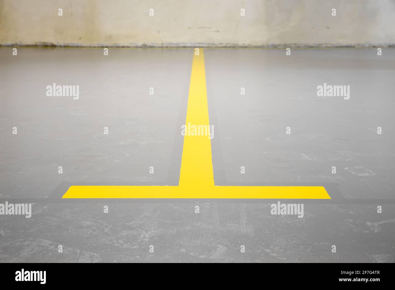 New yellow underground car park marking. Newly painted dividing line mark between two parking lots Stock Photo