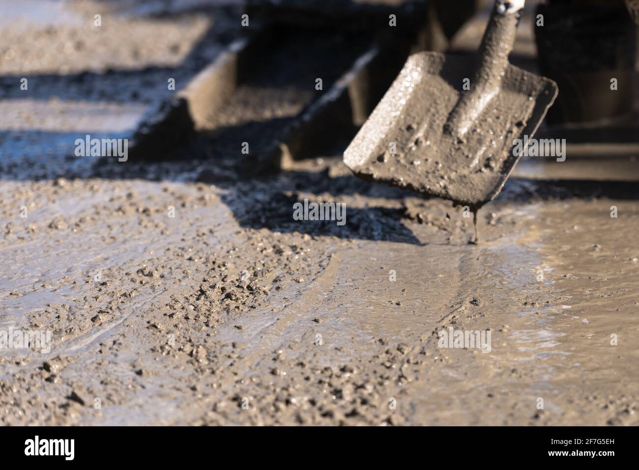 Pouring concrete slabs. Leveling a concrete slab with a hand tool. Scoop shovel helps to work