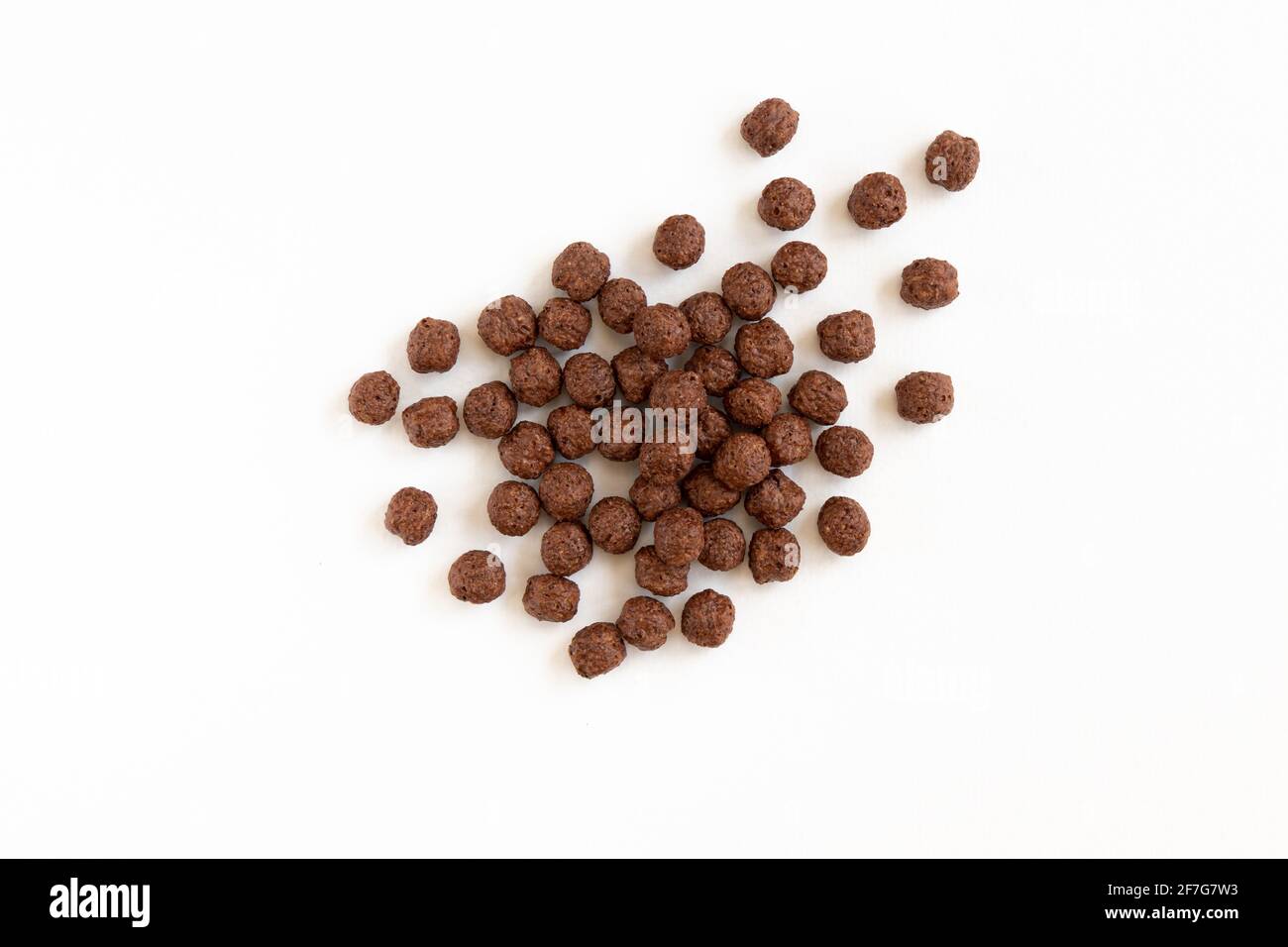 Crunchy chocolate cereal balls isolated on white background. Dry breakfast chocolate flavored balls. Top view Stock Photo