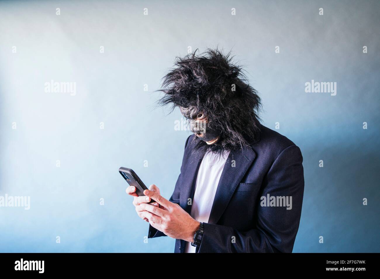 Man with gorilla mask using smart phone Stock Photo