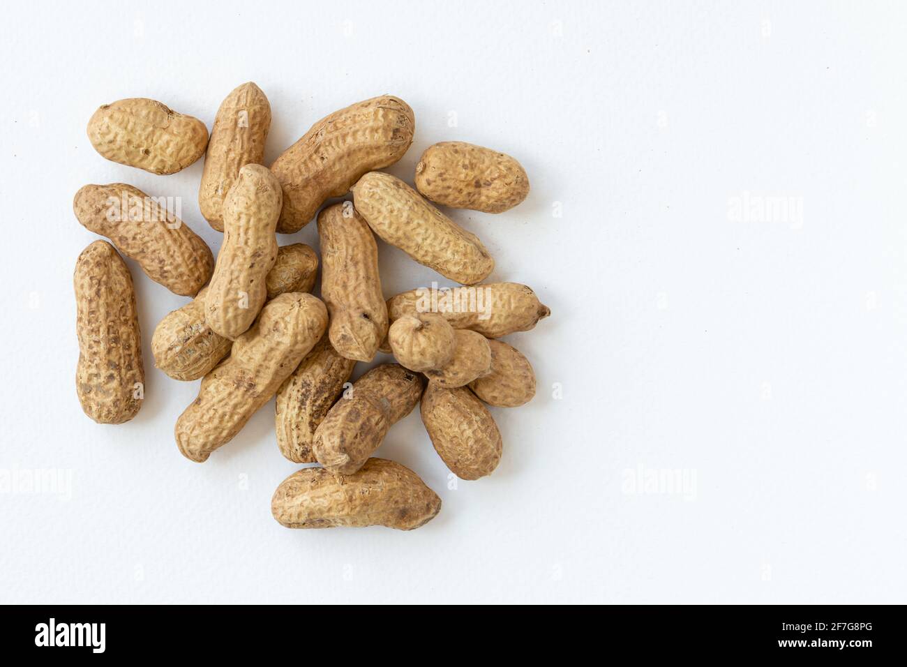 Peanuts or groundnuts in shells, isolated on white background. Unshelled nuts. Stock Photo