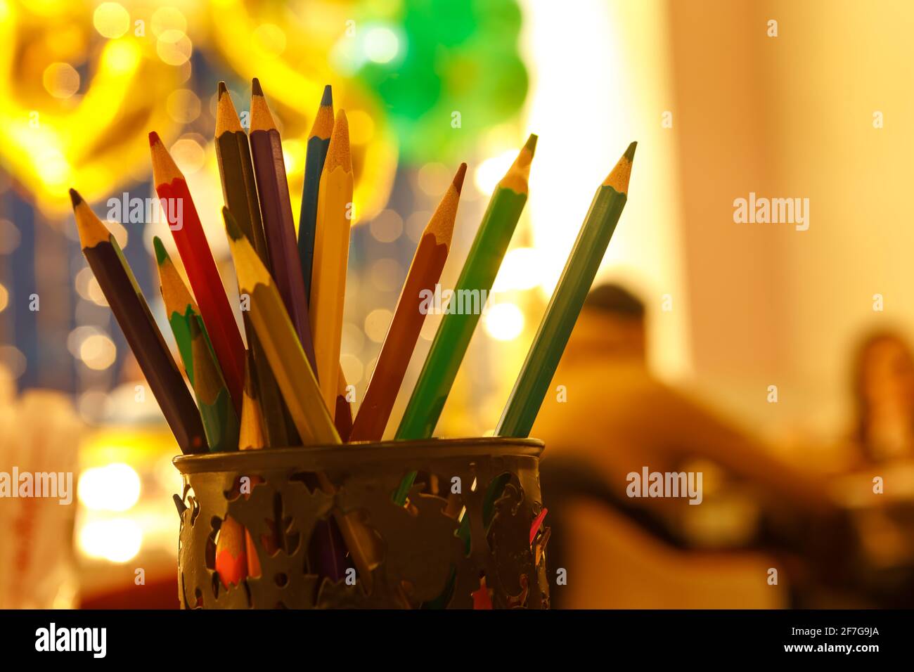 Sharpened colored pencils in a pencil case on a defocused background. Stock Photo