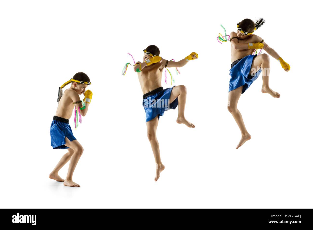 Little boy exercising thai boxing on white background. Fighter practicing, training in martial arts in action, motion. Evolution of movement, catching Stock Photo
