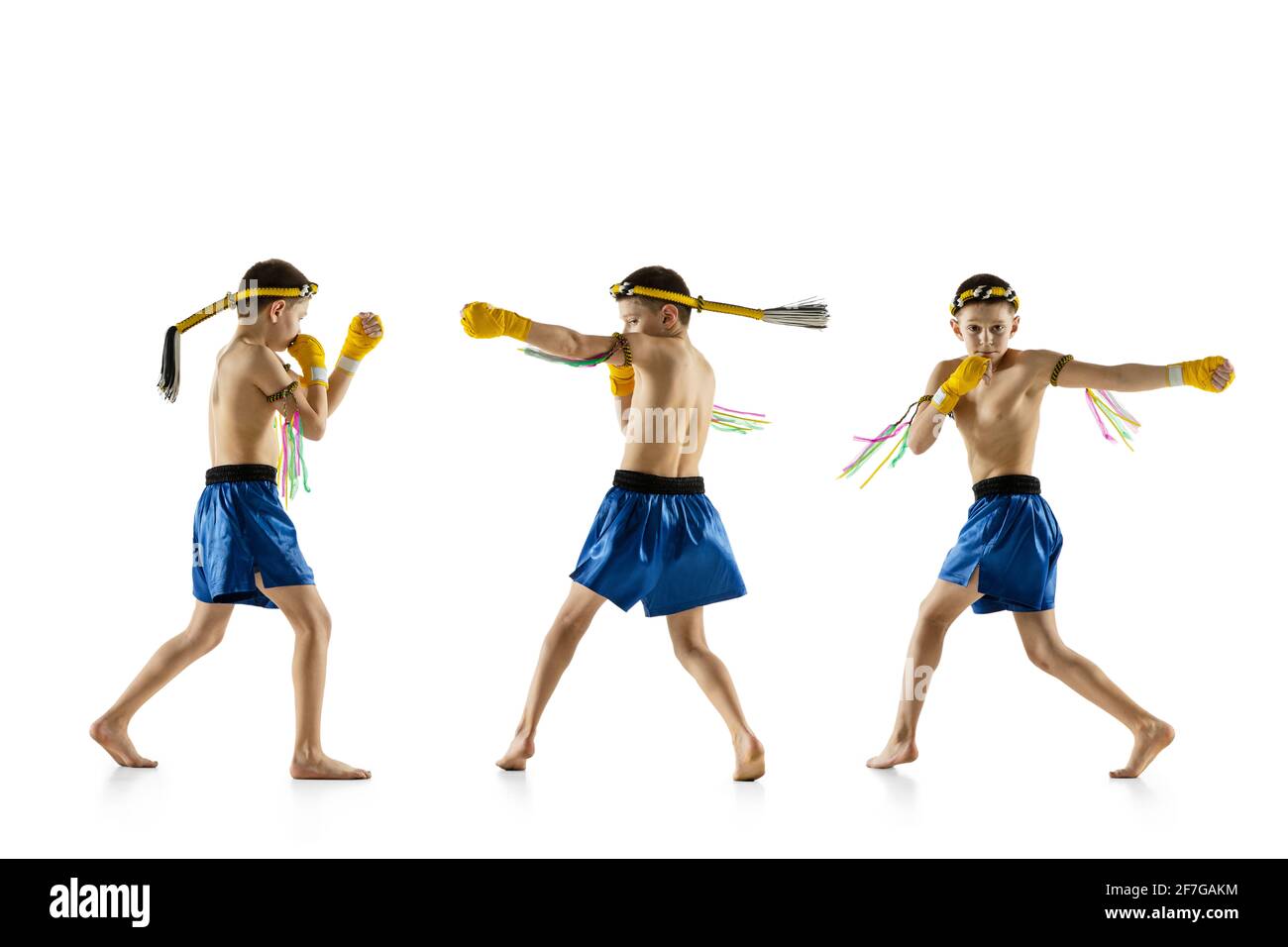 Little boy exercising thai boxing on white background. Fighter practicing, training in martial arts in action, motion. Evolution of movement, catching Stock Photo