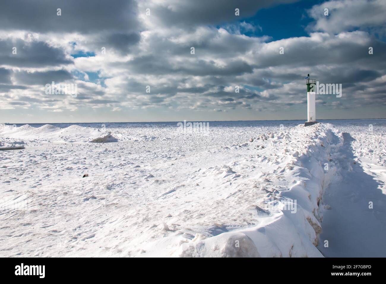 Grand Bend, Ontario, Canada - At the edge of the Grand Bend Pier, the lighthouse looks out onto a thick carpet of ice amid a polar vortex. Stock Photo