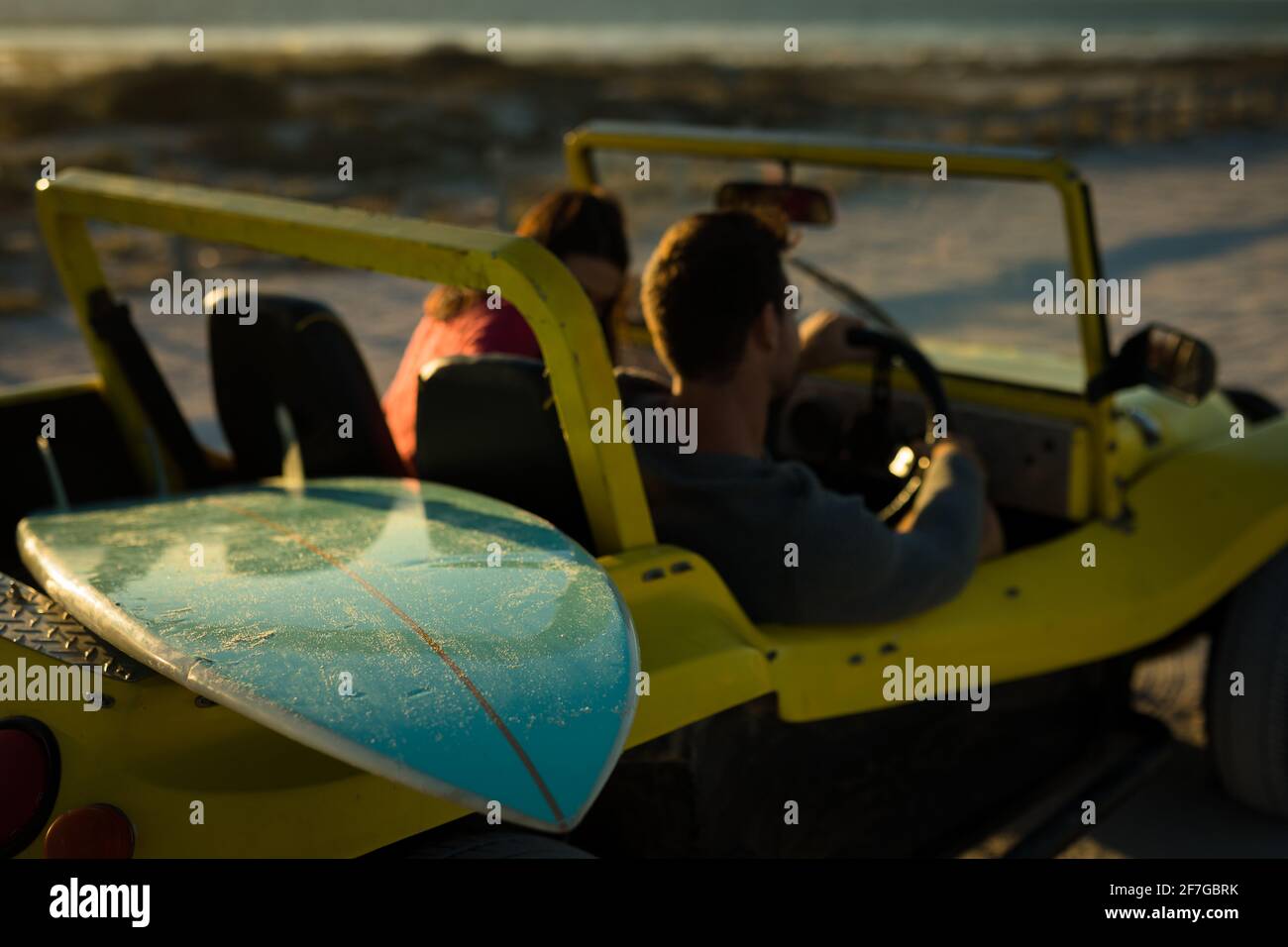 Caucasian couple sitting in beach buggy by the sea talking Stock Photo