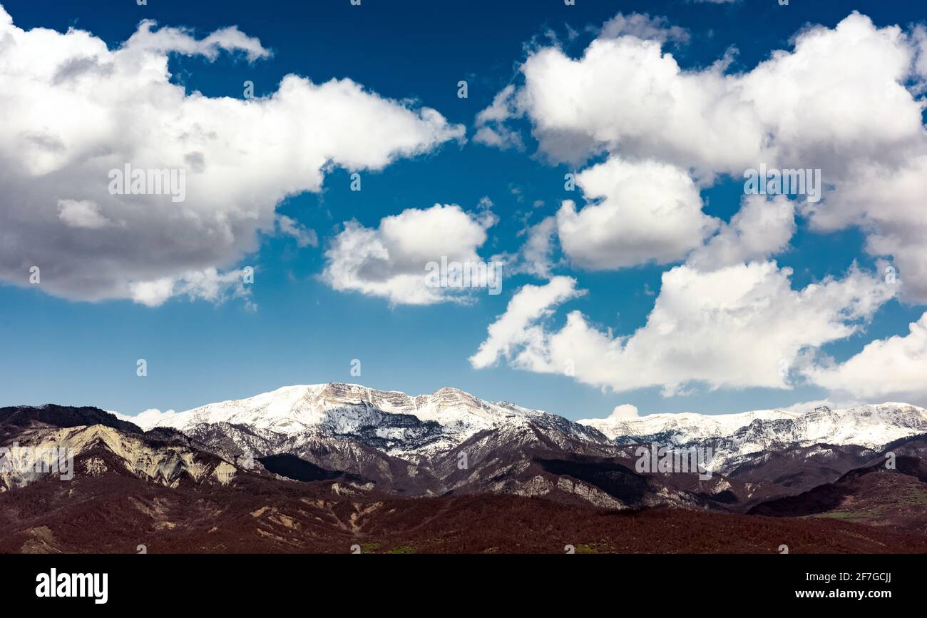 Cloud over snow capped mountain peaks Stock Photo - Alamy