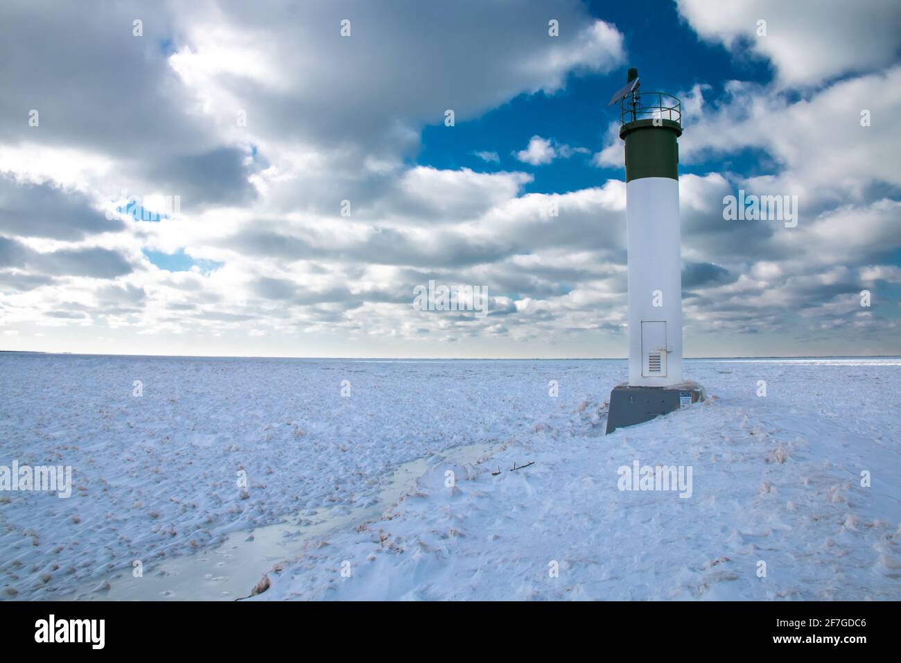 Grand Bend, Ontario, Canada - At the edge of the Grand Bend Pier, the lighthouse looks out onto a thick carpet of ice amid a polar vortex cold snap. Stock Photo