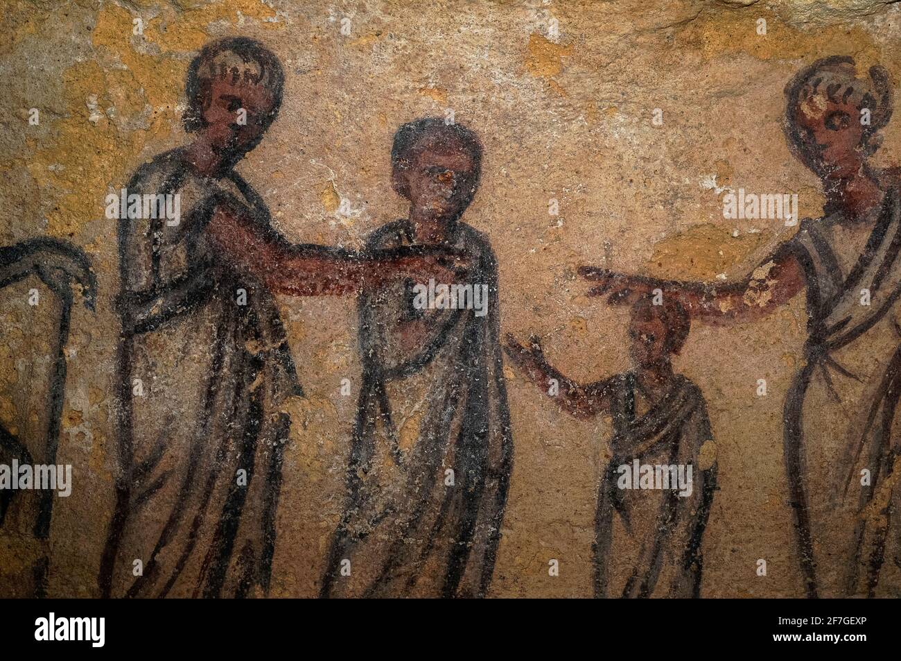 A newly deceased Etruscan woman (right) and young boy are greeted by two predeceased male relatives in the afterlife. The hand of Etruscan deity Charun (left) rests on the long handle of his symbolic hammer as he guards the entrance to the Underworld.  Detail of wall painting in 200s BC Etruscan tomb in the Monterozzi necropolis of the ancient city of Tarchuna or Tarchna, now Tarquinia, Lazio, Italy. Stock Photo