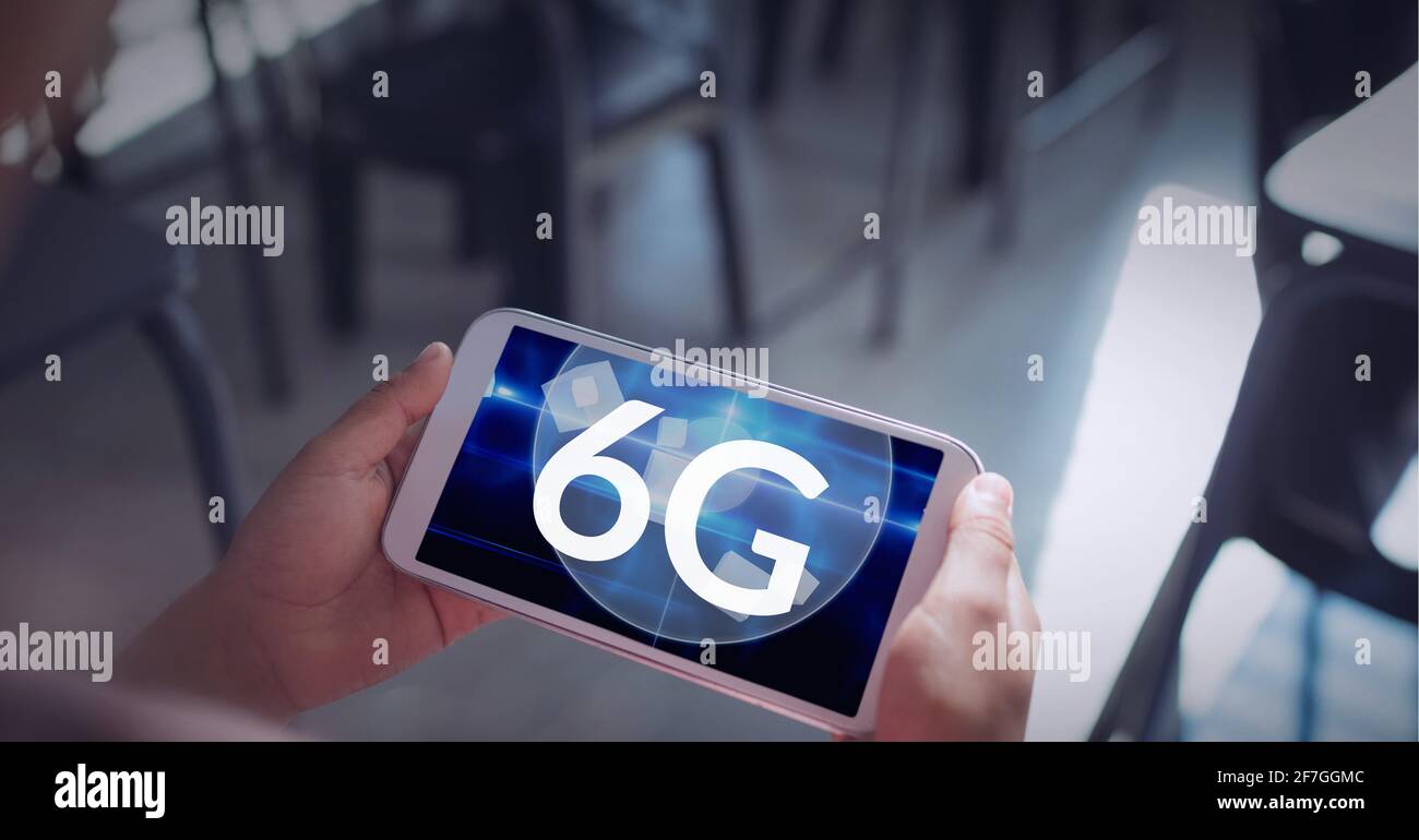 Composition of the word 6g over a person holding a smartphone in background Stock Photo