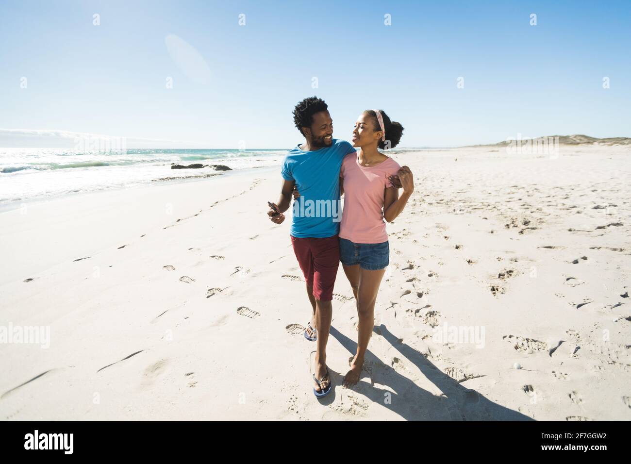 Happy african american couple on beach by the sea embracing Stock Photo ...